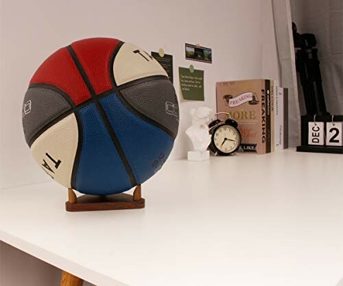 Basketball on a desk with books and an alarm clock.