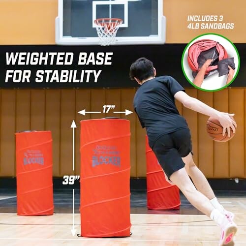 Person dribbling basketball around red training obstacles in a gym.