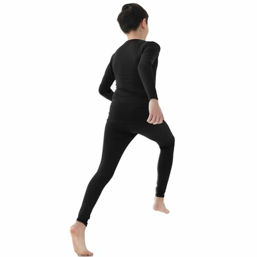 Child wearing black thermal underwear running.