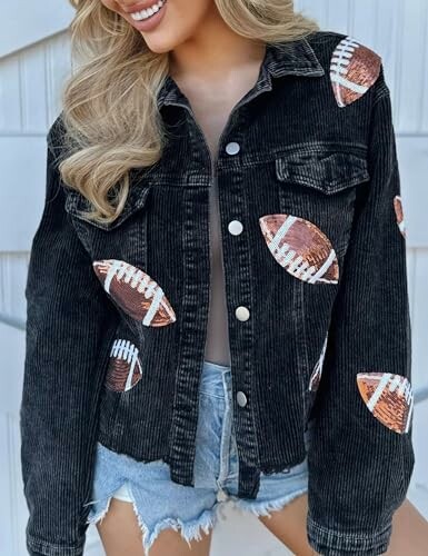 Woman wearing a black denim jacket with football patches and denim shorts.