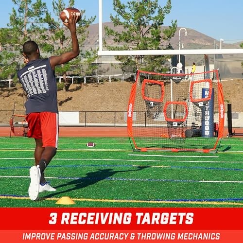 Man practicing football passing with a target net on a sports field.