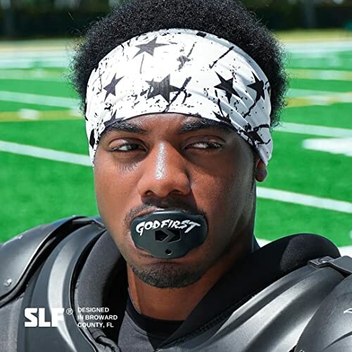 Football player wearing a mouthguard and star-patterned headband.