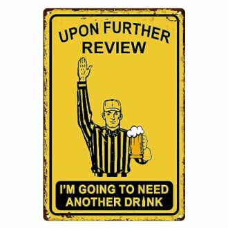 Humorous sign with referee holding a beer, text: 'Upon further review, I'm going to need another drink.'