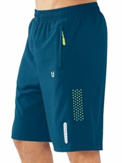 Man wearing blue athletic shorts with zipper pocket and reflective details.