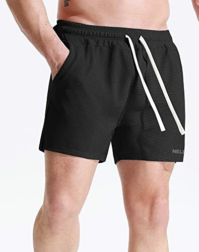 Man wearing black athletic shorts with white drawstrings