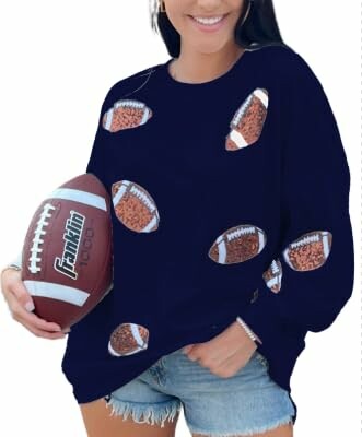 Woman in football-themed sweater holding a football.