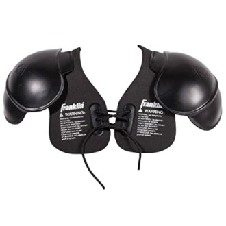 Youth football shoulder pads with laces and warning label.